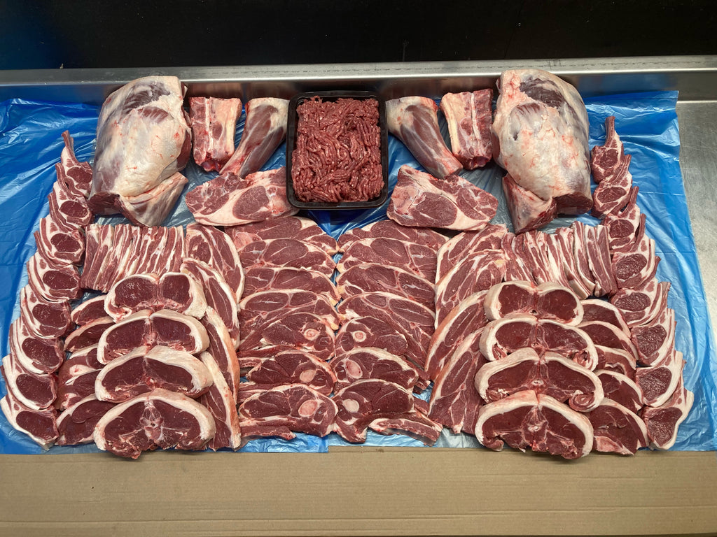 Assorted cuts of raw meat on a blue plastic sheet whole lamb